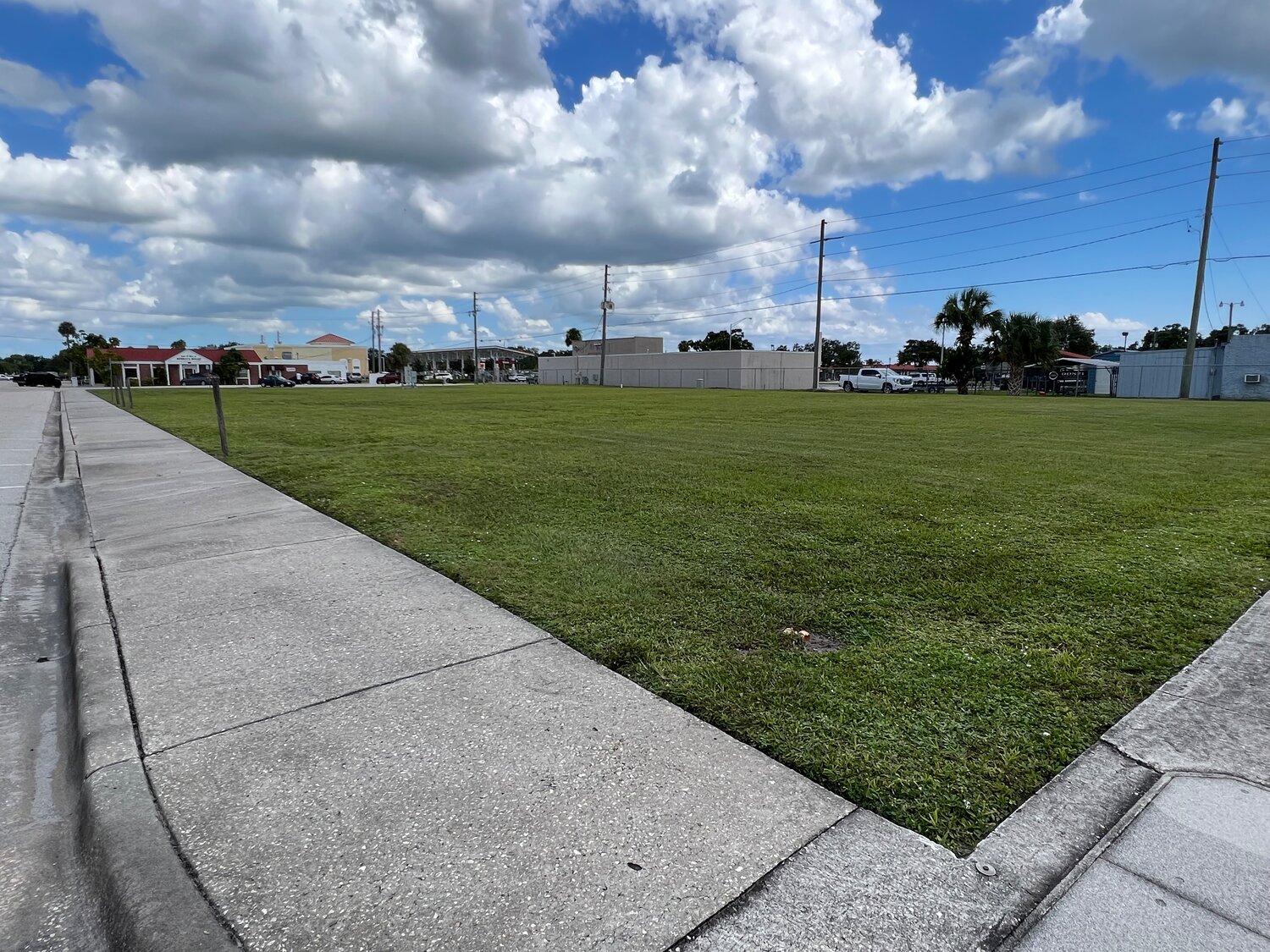 The lot across the street from the Historic Okeechobee County Courthouse is vacant. At one time, it was site of the old Supervisor of Elections Office and Teen Town. The side of the lot next to the alley between this lot at the businesses on SR 70 is fenced.